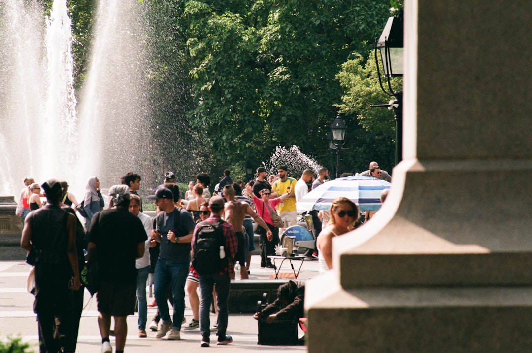 People gathered near a fountain in a park.