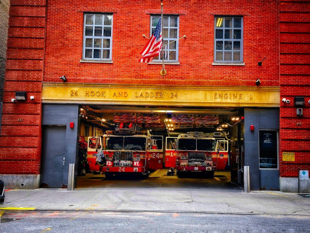 Two fire trucks parked in front of a fire station