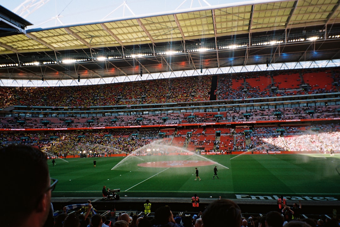 A football stadium with sprinklers on the pitch.